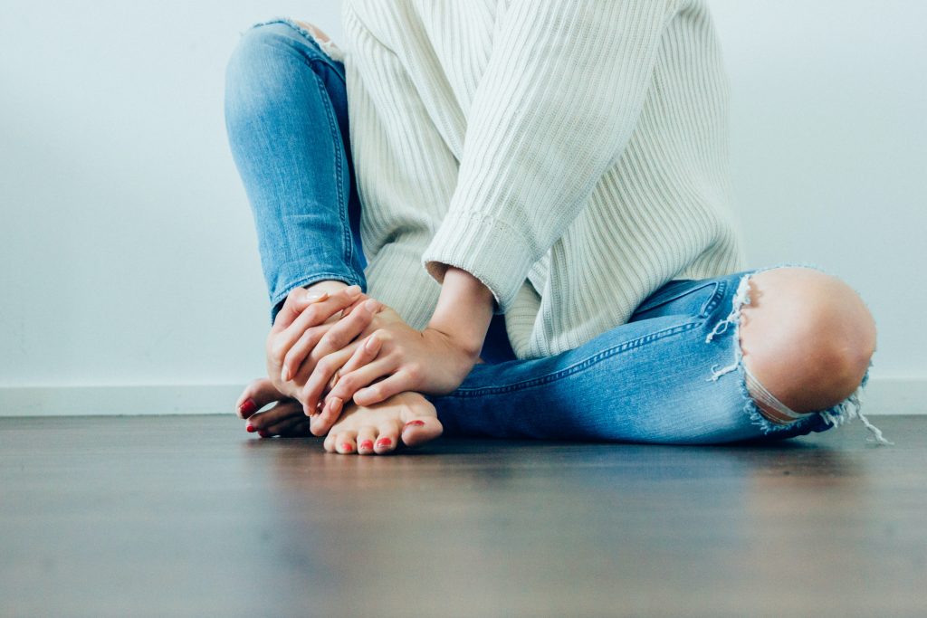 woman rubbing the skin on her feet 