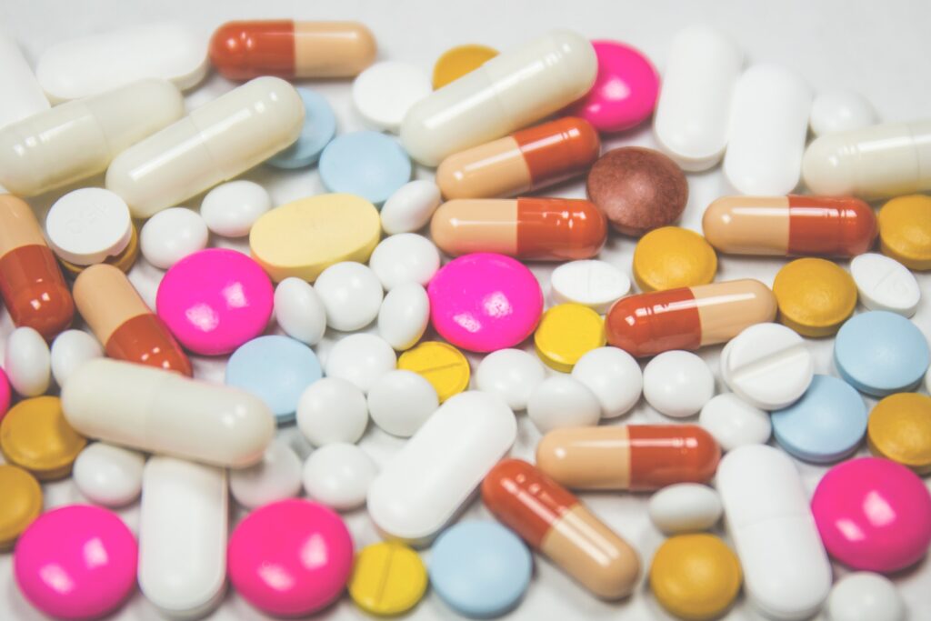 A collection of brightly coloured pills on a white surface