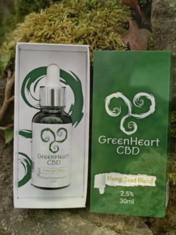 An open box displaying a green and white bottle of Greenheart CBD