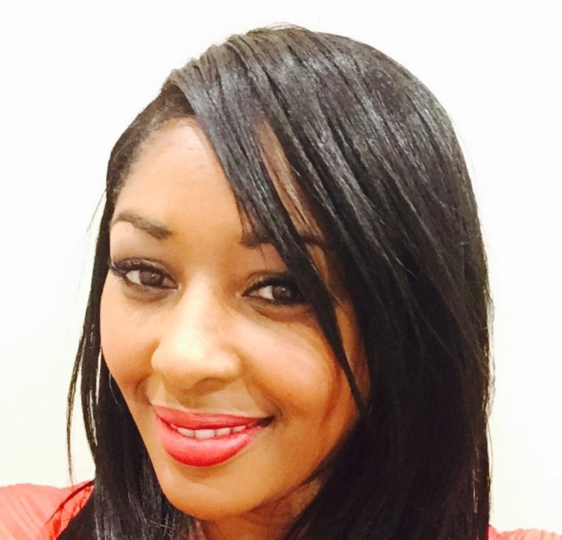 A woman in a red shirt and long hair poses for a selfie. 