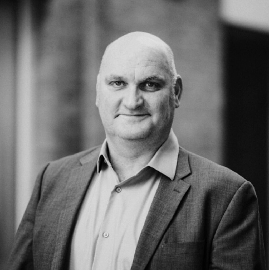 A black and white image of a man wearing a suit. 