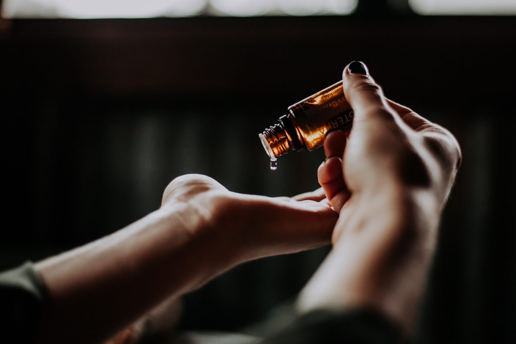 Two hands pouring CBD oil onto the palms.