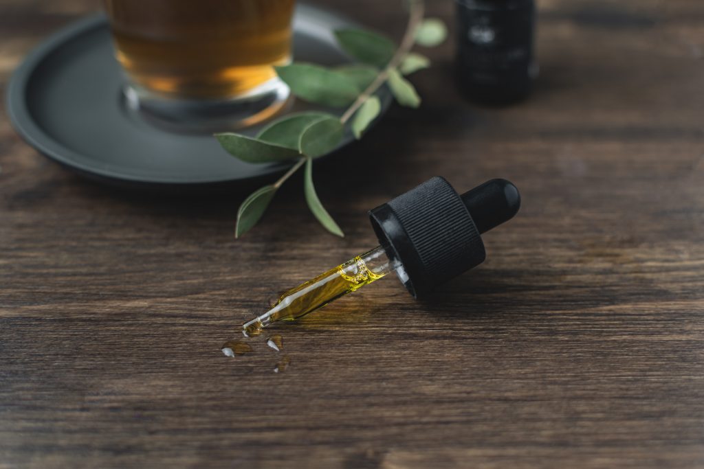 An oil dropper lying on its side on a wooden table