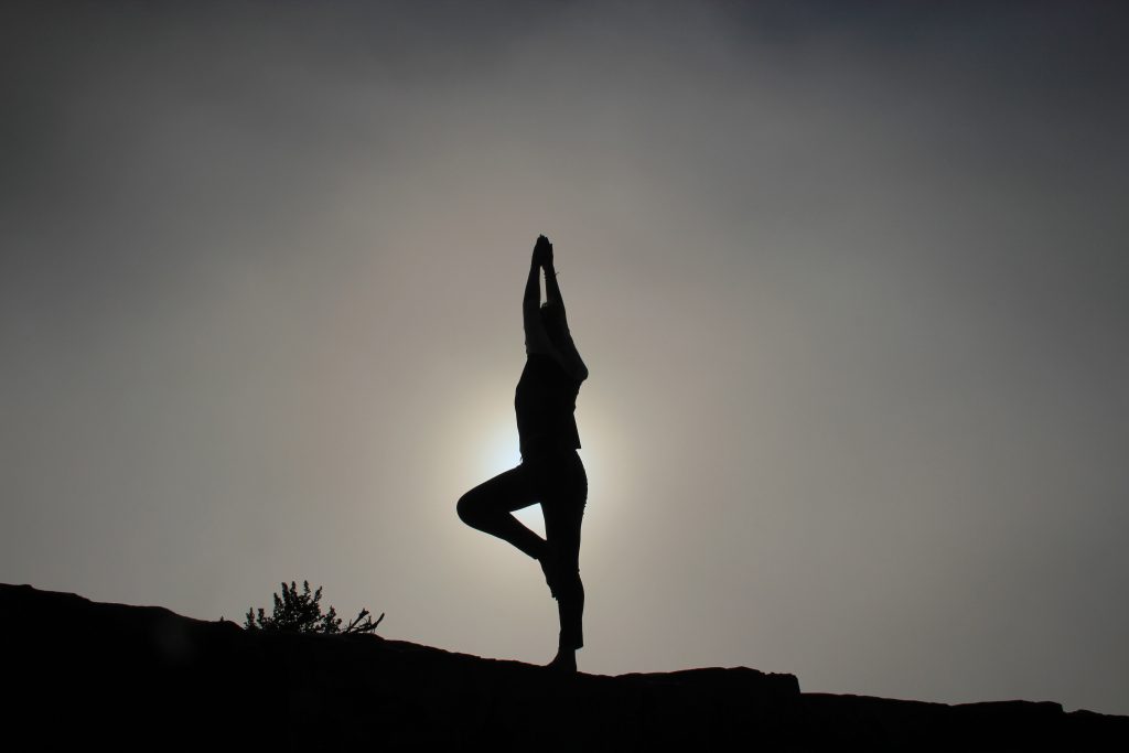 A person doing yoga n black and white against a sunset